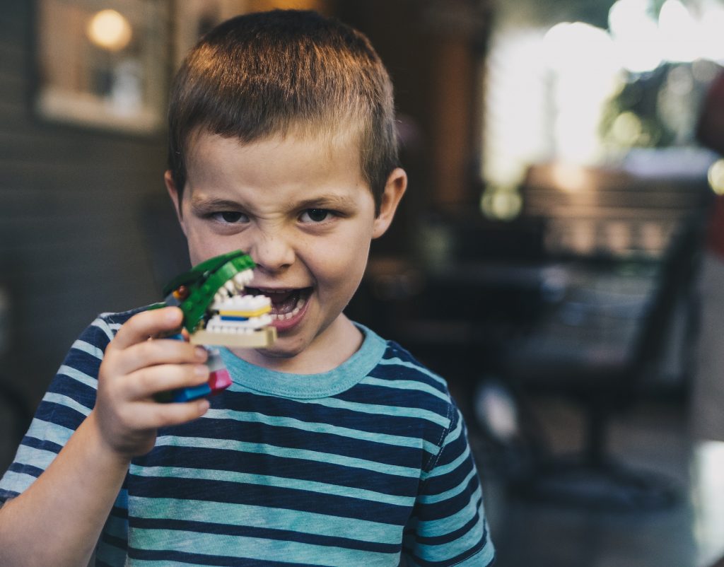 child holding a dinosaur toy joyfully