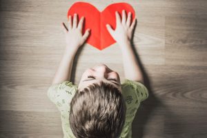 toddler holding a paper heart