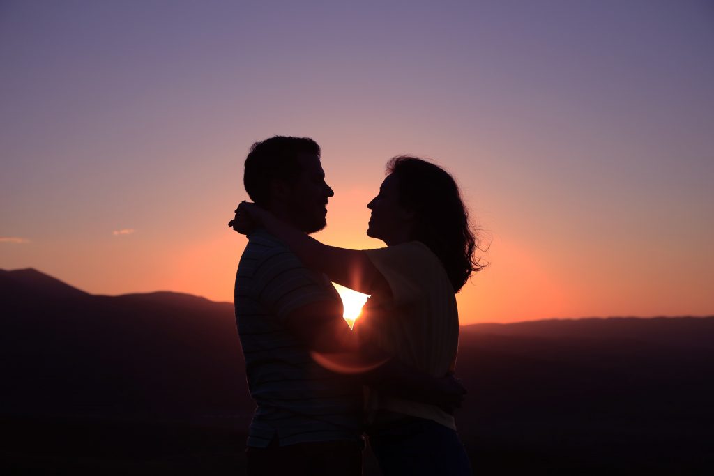 happy couple hugging and enjoying sunset