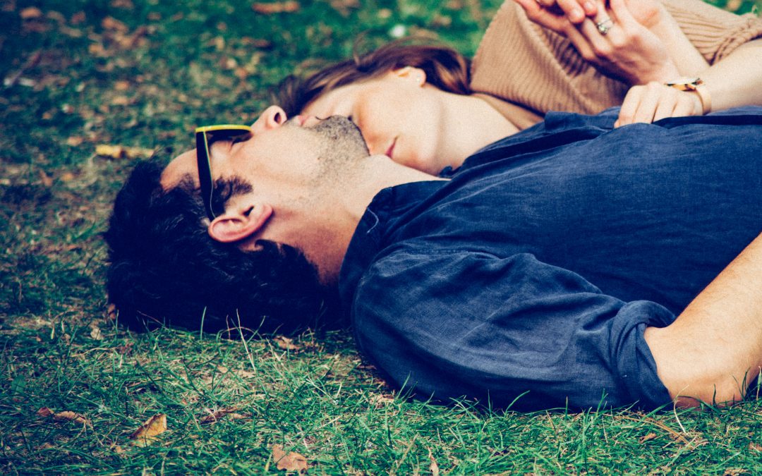 couple holding each other while laying on the ground