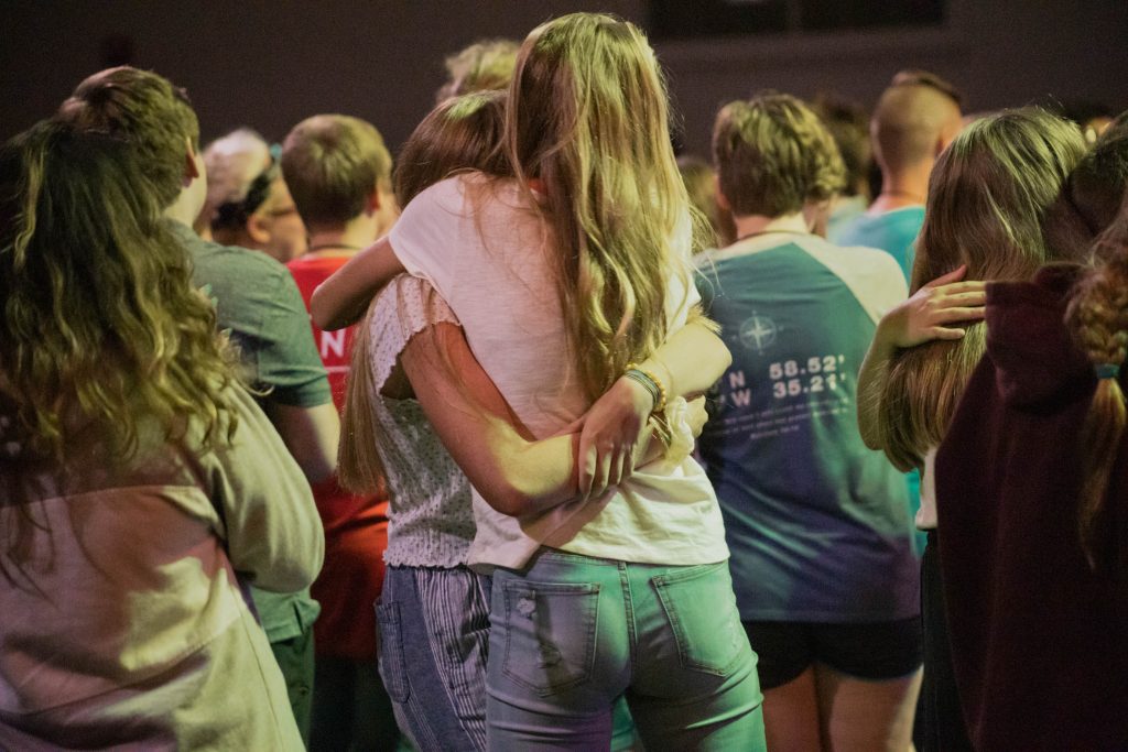 a group of young people enjoying a concert and hugging