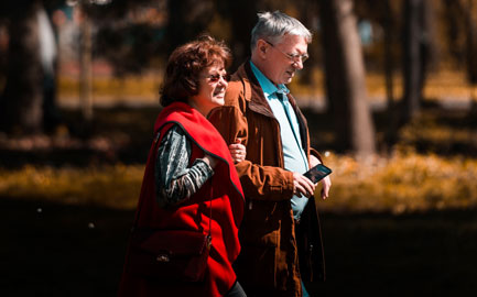 older couple walking hand in hand in the park 