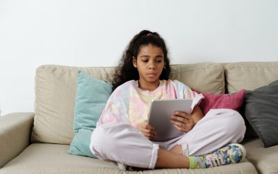 child holding an iPad with the look of distress on their face