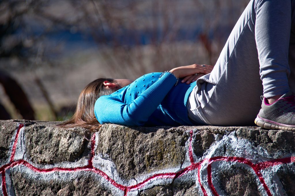 woman laying on stone wall 