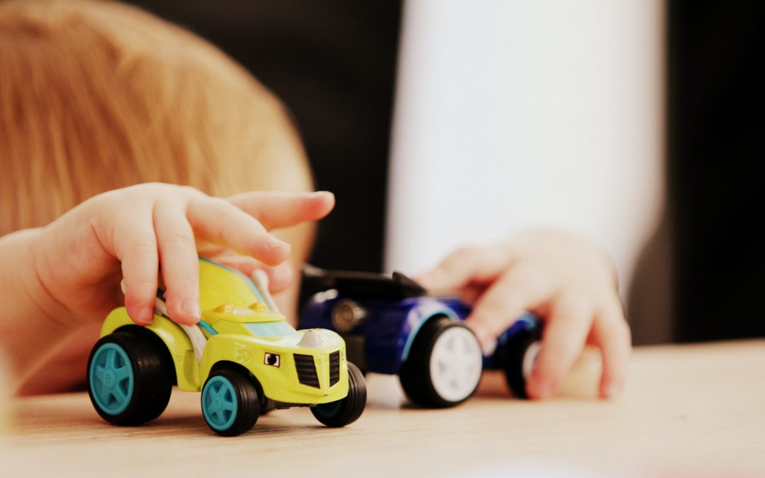 toddler hands grabbing a toy car