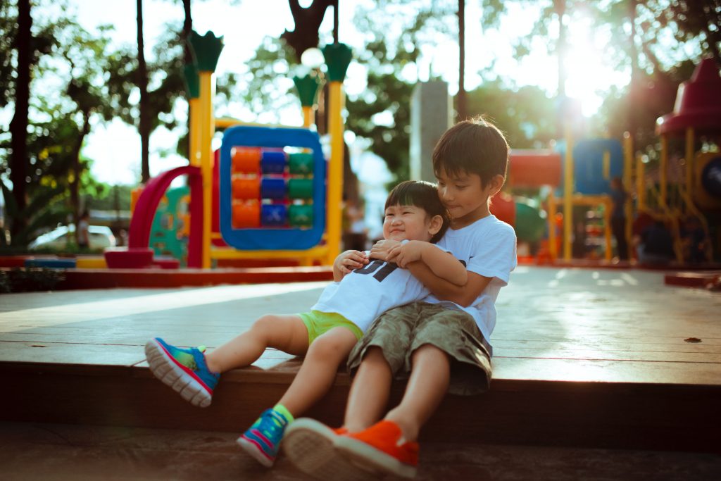 two boys playing at a park 