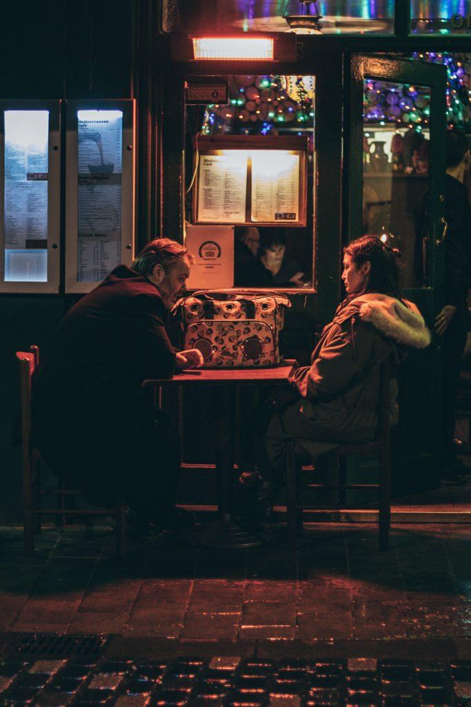 a couple sitting at a table in a dark cafe 