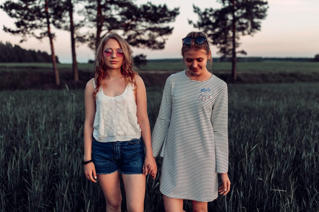 two girls standing and holding hands