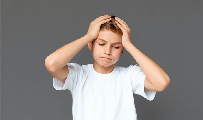 boy stressed out and holding his head with palms
