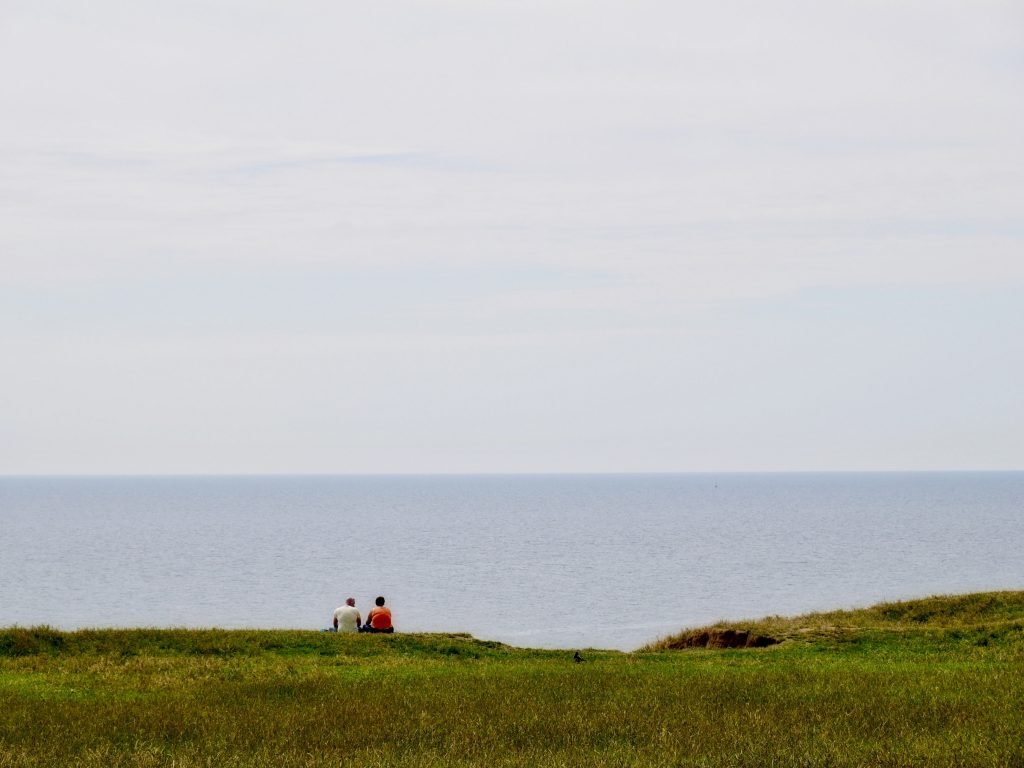couple sitting together near the coast