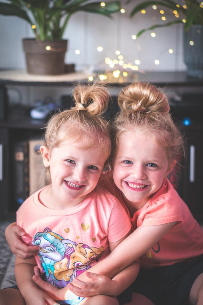two little girls hugging and smiling