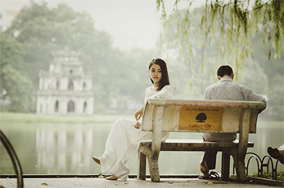 couple sitting on bench but looking away from each other