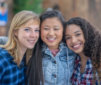 Three girls close together smiling