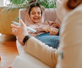 A littel girl laughing and laying on a couch