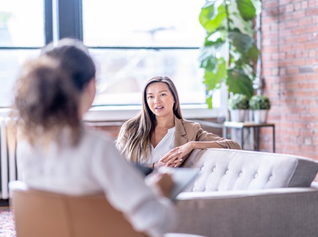 Image of two professional women sitting on a couch talking to each other. Are you struggling with the loss of a loved one? Learn how grief counseling in Simi Valley, CA can help provide you with support.