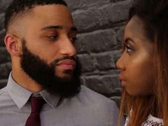 
A man with a beard and a woman looking at each other.