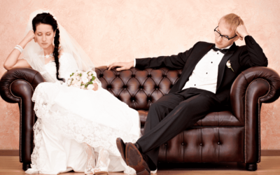 a person in a suit sitting on a couch with a person in a wedding dress