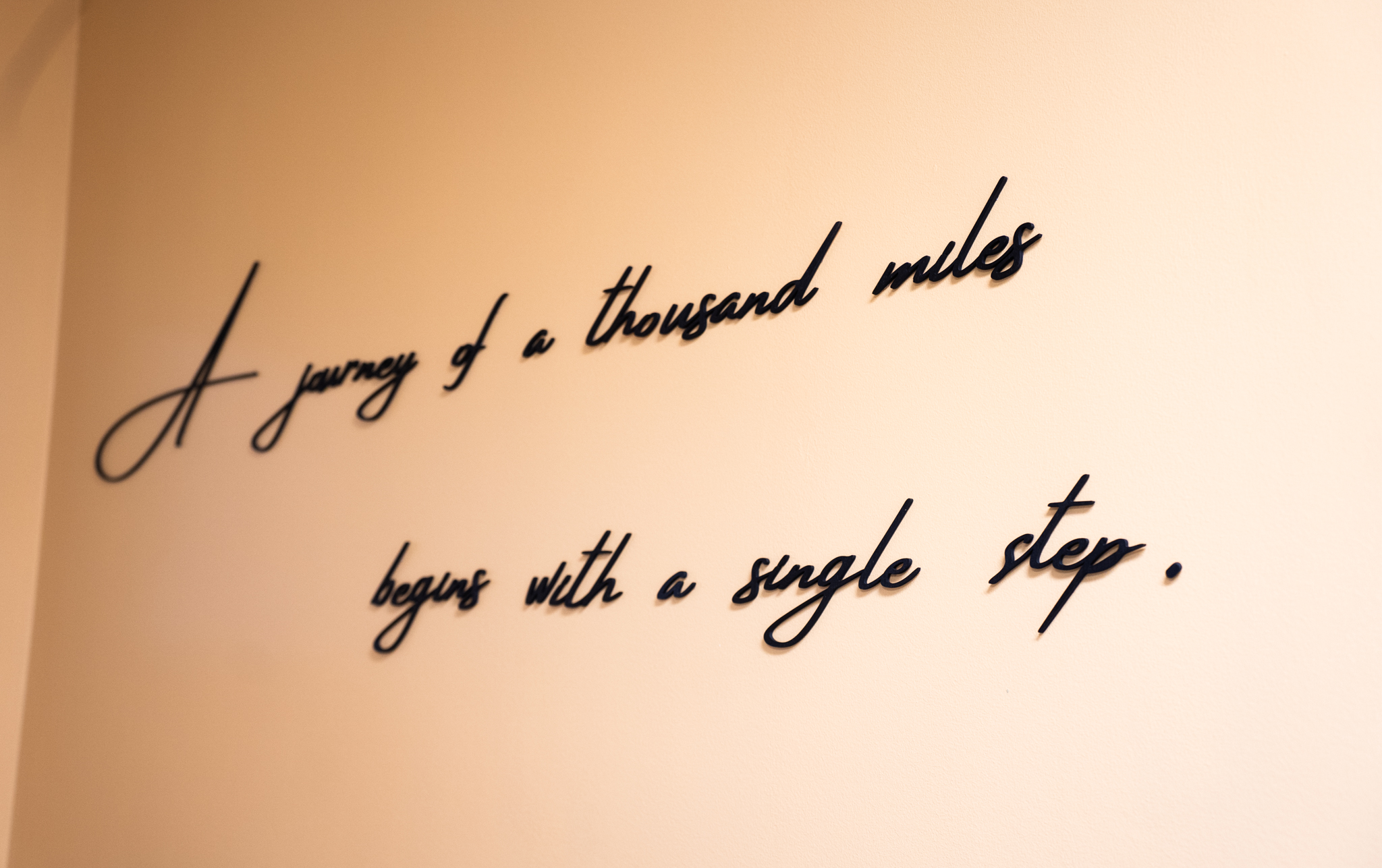 Quote on wall that says "A journey of a thousand miles begins with a single step."