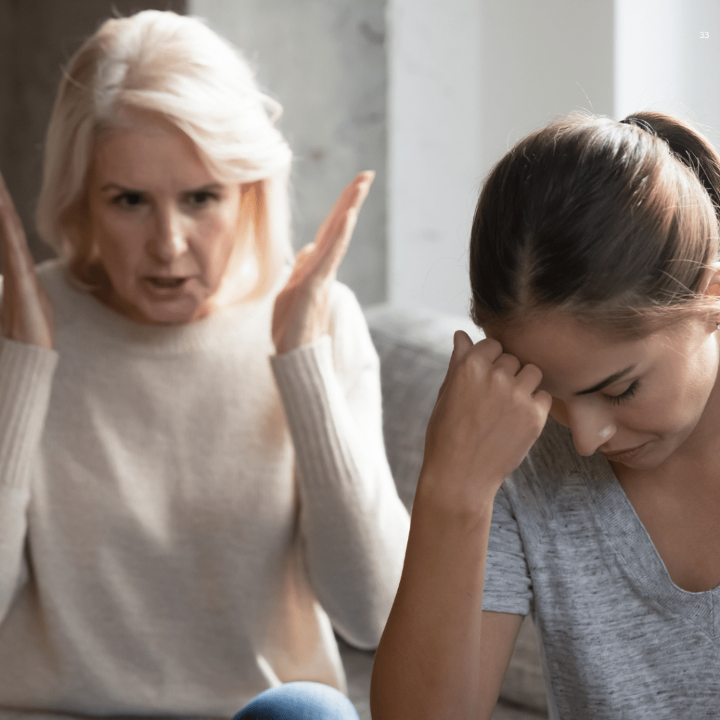 A concerned daughter watches as her mother holds her head, indicating a moment of stress or discomfort.