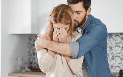 A couple hugs affectionately in a kitchen, showcasing a moment of love and connection amidst a welcoming atmosphere.