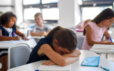 Child at her desk in a classroom with her head down looking defeated or tired. ADHD or anxiety Thousand Oaks.